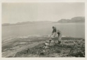 Image of Miriam MacMillan examining rock cairn on shore